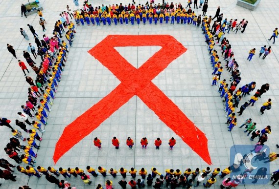 Pupils show a huge red ribbon, the HIV/AIDS awareness symbol, formed by red scarves to mark the World AIDS Day in Dexing City, east China's Jiangxi Province, Dec. 1, 2015.(Photo: Xinhua/Zhuo Zhongwei) Pupils show a huge red ribbon, the HIV/AIDS awareness symbol, formed by red scarves to mark the World AIDS Day in Dexing City, east China's Jiangxi Province, Dec. 1, 2015.(Photo: Xinhua/Zhuo Zhongwei)