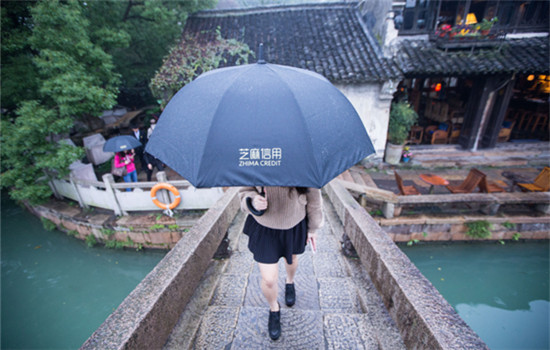 A tourist walks on a bridge with an umbrella borrowed via Zhima Credit, which is under Alibaba's affiliate Ant Financial, in Wuzhen, Zhejiang province, Nov 17, 2016. (XU KANGPING / FOR CHINA DAILY) A tourist walks on a bridge with an umbrella borrowed via Zhima Credit, which is under Alibaba's affiliate Ant Financial, in Wuzhen, Zhejiang province, Nov 17, 2016. (XU KANGPING / FOR CHINA DAILY)