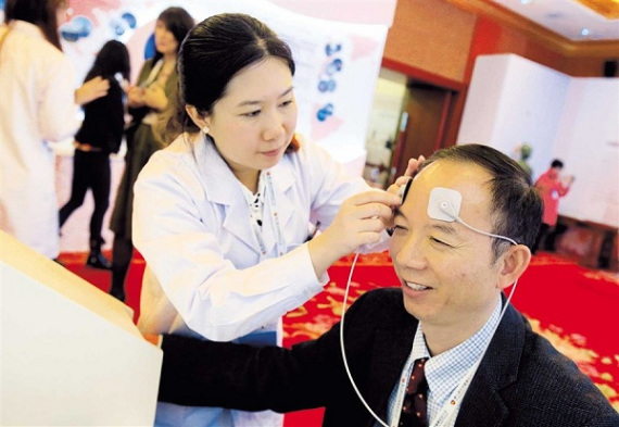 A conference delegate tries out a sensor system used in traditional Chinese medicine.(Photo/Xinhua) A conference delegate tries out a sensor system used in traditional Chinese medicine.(Photo/Xinhua)