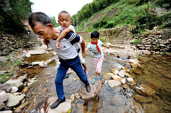Two left-behind children follow their teacher to school in a mountainous area of Jiangxi province. (Zhuo Zhongwei/China Daily) Two left-behind children follow their teacher to school in a mountainous area of Jiangxi province. (Zhuo Zhongwei/China Daily)