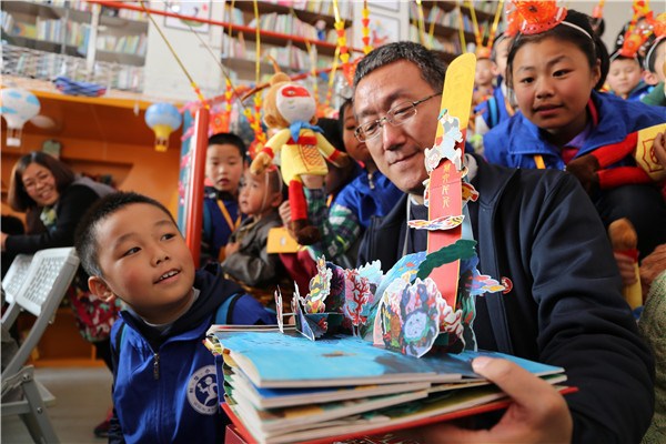 Yan Hongbing, the paper-art designer of the book, with children at a promotional event in Xi'an. (Photo provided to China Daily) Yan Hongbing, the paper-art designer of the book, with children at a promotional event in Xi'an. (Photo provided to China Daily)