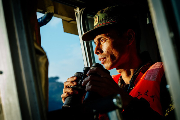 Tan Jianhua watches traffic during a patrol drill. Photo By Qian Cheng / For China Daily Tan Jianhua watches traffic during a patrol drill. Photo By Qian Cheng / For China Daily