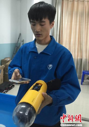 A student controls the robot fish with a mobile phone. (Photo: Chinanews.com/Liu Yutao) A student controls the robot fish with a mobile phone. (Photo: Chinanews.com/Liu Yutao)