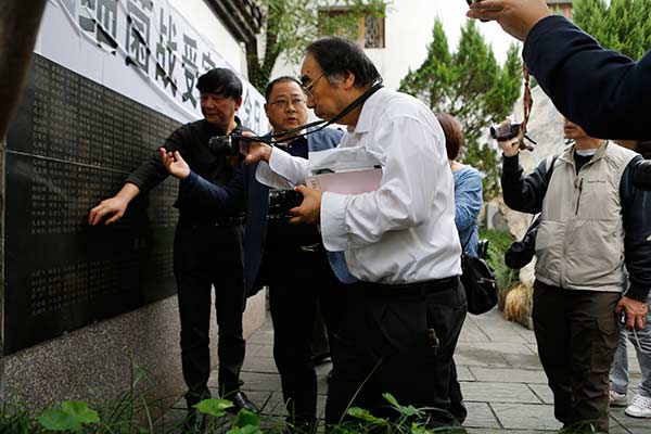 Japanese lawyer Keiichiro Ichinose (right) at the Quzhou Germ Warfare Victims Memorial Museum in Zhejiang in October as he takes a photo of a list of those who died as a result of Japan's biological weapons. (Photo by Han Qiang/For China Daily) Japanese lawyer Keiichiro Ichinose (right) at the Quzhou Germ Warfare Victims Memorial Museum in Zhejiang in October as he takes a photo of a list of those who died as a result of Japan's biological weapons. (Photo by Han Qiang/For China Daily)