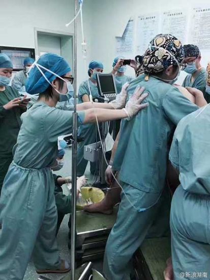 Medical staff members help the woman deliver the baby. (Photo from Sina Weibo) Medical staff members help the woman deliver the baby. (Photo from Sina Weibo)
