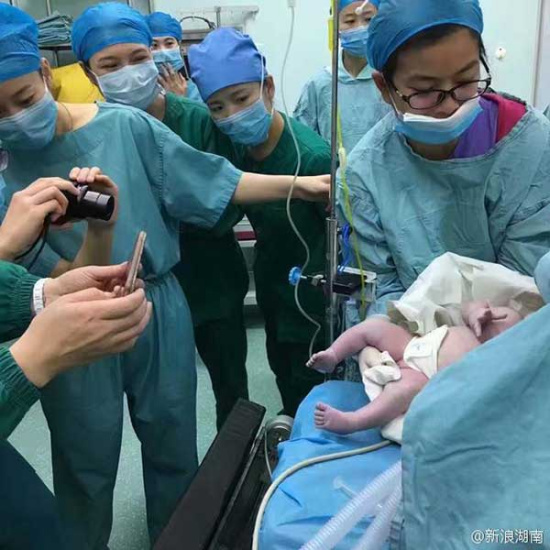 Medical staff members take photos for the newborn. (Photo from Sina Weibo) Medical staff members take photos for the newborn. (Photo from Sina Weibo)