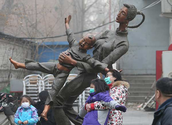A mother and daughter wear masks as they pose with a statue in Beijing's Wangjing area on Sunday. (Photo: WANG ZHUANGFEI/CHINA DAILY) A mother and daughter wear masks as they pose with a statue in Beijing's Wangjing area on Sunday. (Photo: WANG ZHUANGFEI/CHINA DAILY)