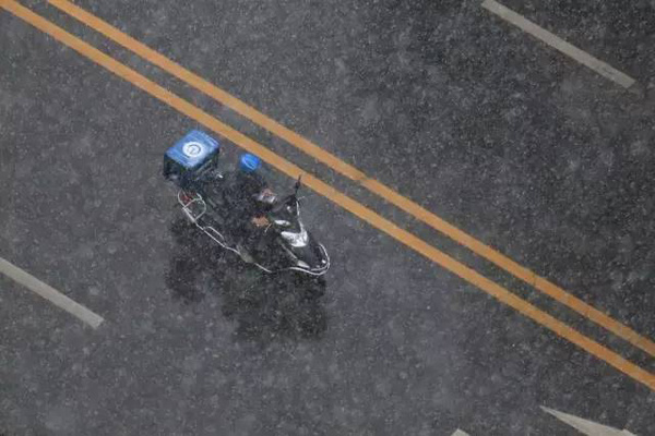 A deliveryman makes his way down the road in Beijing on a snowy day. (Photo from the web) A deliveryman makes his way down the road in Beijing on a snowy day. (Photo from the web)