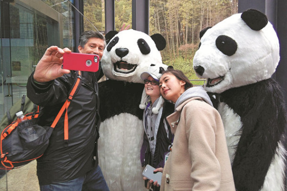 Madelyn Ruyle (middle), 11, from the United States, is one of 17 United Nations panda champions, 15 of whom are visiting Chengdu, Sichuan province, this week. Her father, who accompanied her, takes a photo. (Photo/China Daily) Madelyn Ruyle (middle), 11, from the United States, is one of 17 United Nations panda champions, 15 of whom are visiting Chengdu, Sichuan province, this week. Her father, who accompanied her, takes a photo. (Photo/China Daily)