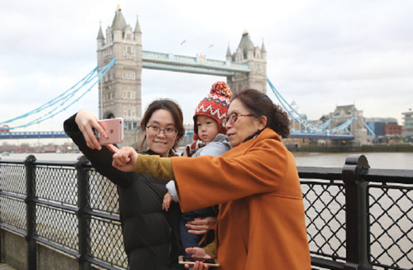Three Chinese tourists pose for a selfie next to the River Thames in London. (Photo/chinadaily.com.cn) Three Chinese tourists pose for a selfie next to the River Thames in London. (Photo/chinadaily.com.cn)
