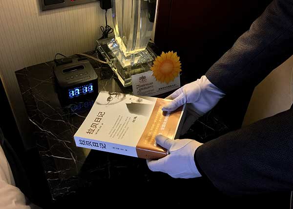 An employee of a hotel in Taizhou, Zhejiang province, puts The Good Man of Nanking: The Diaries of John Rabe in a guest room on Friday.(Photo provided to China Daily) An employee of a hotel in Taizhou, Zhejiang province, puts The Good Man of Nanking: The Diaries of John Rabe in a guest room on Friday.(Photo provided to China Daily)