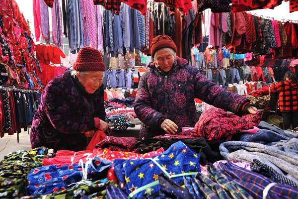 Farmers look at clothes at a market in Zaozhuang city's Shanting district, in East China's Shandong province, before the Spring Festival.Li Zongxian / For China Daily Farmers look at clothes at a market in Zaozhuang city's Shanting district, in East China's Shandong province, before the Spring Festival.Li Zongxian / For China Daily