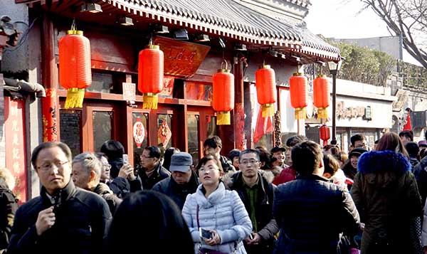 Visitors stroll through Nanluoguxiang, a popular alleyway in Beijing, after the completion of a renovation project earlier this month.(Photo by Li Xin/Xinhua) Visitors stroll through Nanluoguxiang, a popular alleyway in Beijing, after the completion of a renovation project earlier this month.(Photo by Li Xin/Xinhua)