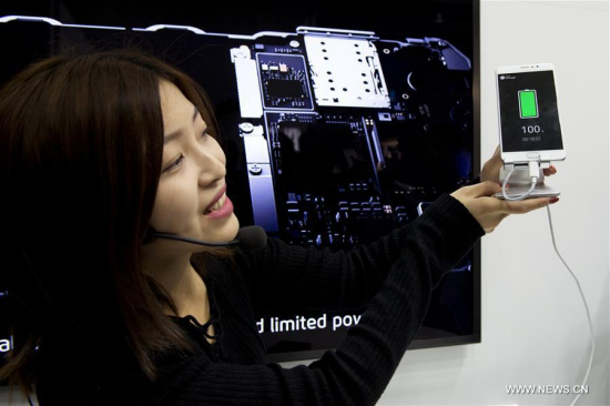 An employee from smartphone maker Meizu shows a device recently charged during the Mobile World Congress in Barcelona, Spain, Feb. 28, 2017. (Xinhua/Lino De Vallier)
