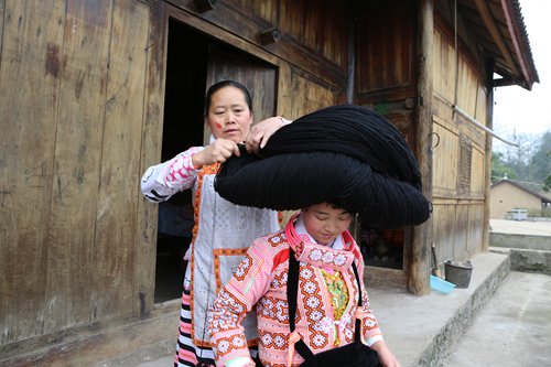 Yang Ermei's mother-in-law helps Yang Ermei put on the headdress. (Photo: Chen Qingqing/GT) Yang Ermei's mother-in-law helps Yang Ermei put on the headdress. (Photo: Chen Qingqing/GT)