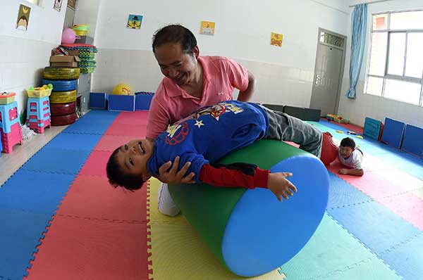 Special education teacher Dai Jianrong helps a disabled child complete sensory integration training in Kunming, Yunnan province. (Photo/Xinhua) Special education teacher Dai Jianrong helps a disabled child complete sensory integration training in Kunming, Yunnan province. (Photo/Xinhua)