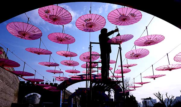 A worker hangs ornaments at the Ming Dynasty City Wall Ruins Park under a blue sky in Beijing this month. LIU PING/CHINA DAILY A worker hangs ornaments at the Ming Dynasty City Wall Ruins Park under a blue sky in Beijing this month. LIU PING/CHINA DAILY