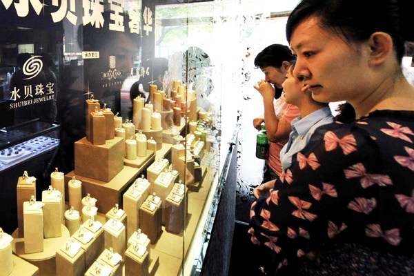 Customers examine jewelry in Shuibei village, Guangdong province, once a leading production center in China. (Photo/Xinhua) Customers examine jewelry in Shuibei village, Guangdong province, once a leading production center in China. (Photo/Xinhua)