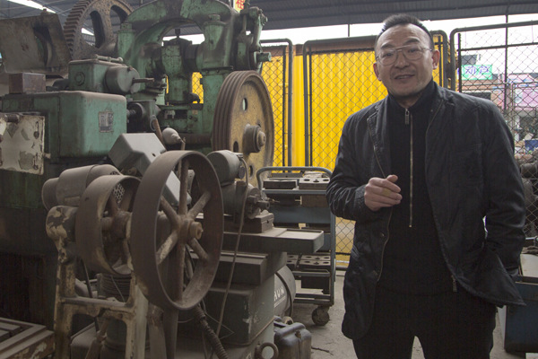 Tang Shigang poses with part of his collection of antique machine tools in Chongqing. (Photo provided to China Daily) Tang Shigang poses with part of his collection of antique machine tools in Chongqing. (Photo provided to China Daily)