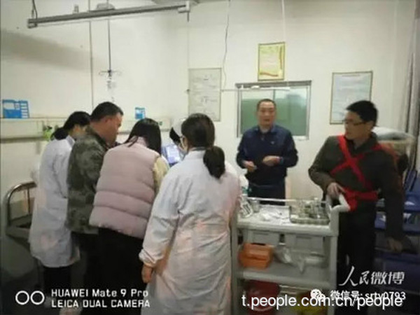 Xu Yilong (right, first) carries out emergency procedure while carrying his daughter on his back at Yushan People's Hospital in Jiangxi province on March 25. (Photo from t.people.com.cn) Xu Yilong (right, first) carries out emergency procedure while carrying his daughter on his back at Yushan People's Hospital in Jiangxi province on March 25. (Photo from t.people.com.cn)