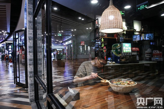 A young man enjoys his dinner for one in Beijing. (Photo/CNR) A young man enjoys his dinner for one in Beijing. (Photo/CNR)