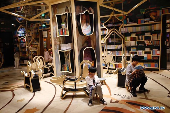 An adult read books with a child at Zhongshuge bookshop in Hangzhou, capital of east China's Zhejiang Province, April 21, 2017. The bookshop with the elements of the amusement park, such as roller coasters, hot air balloons, the merry go round, and attracted many children and their family members. (Xinhua/Zhang Cheng) An adult read books with a child at Zhongshuge bookshop in Hangzhou, capital of east China's Zhejiang Province, April 21, 2017. The bookshop with the elements of the amusement park, such as roller coasters, hot air balloons, the merry go round, and attracted many children and their family members. (Xinhua/Zhang Cheng)
