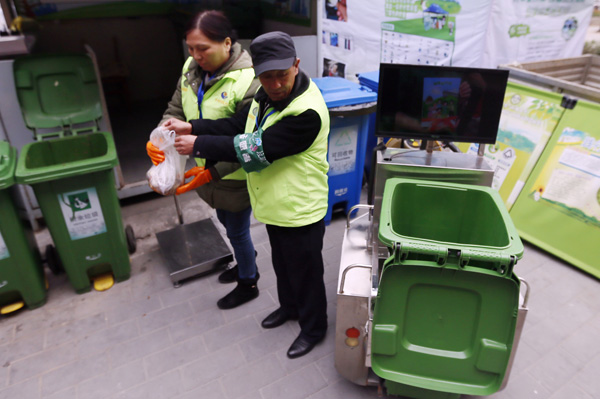 Staff weigh trash prior to handing out credit coupons. (Photo by Cao Boyuan/For China Daily) Staff weigh trash prior to handing out credit coupons. (Photo by Cao Boyuan/For China Daily)