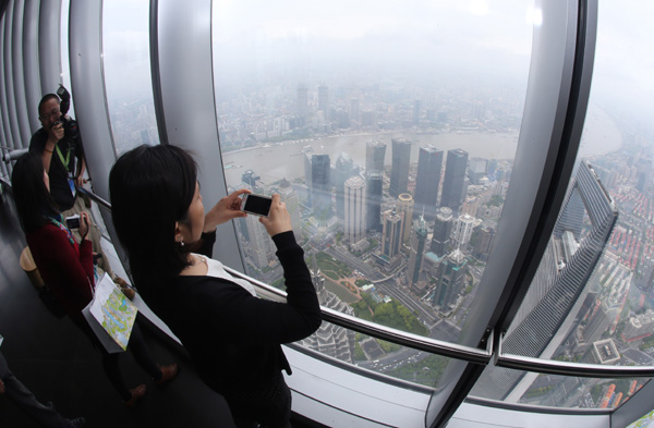 Visitors take photos from the observation deck on the 118th floor of Shanghai Tower on Wednesday, at a height of 546 meters above the ground.(Shao Jianping / For China Daily) Visitors take photos from the observation deck on the 118th floor of Shanghai Tower on Wednesday, at a height of 546 meters above the ground.(Shao Jianping / For China Daily)