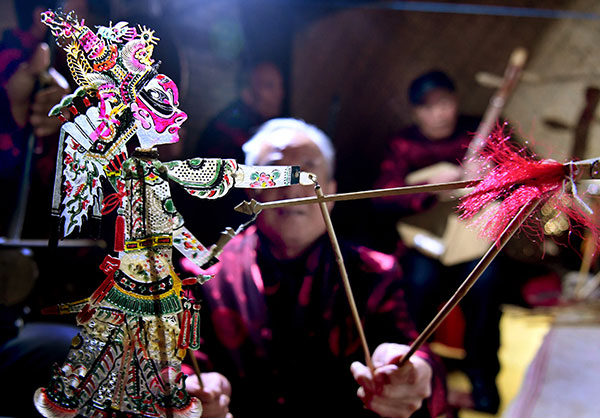 A puppeteer performs a traditional shadow play at Huazhou Shadow Puppet Culture Hall in Huazhou, Shaanxi province.(Tao Ming / Xinhua)