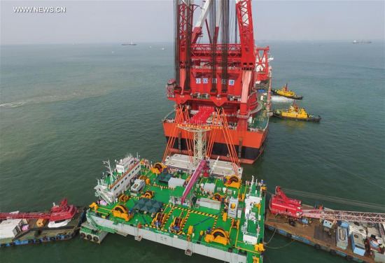 A gigantic crane, which was transformed from a tanker, hoists a 6,000-ton key structure of the world's longest cross-sea bridge linking Hong Kong, Zhuhai and Macao, May 2, 2017. (Xinhua/Liu Dawei) A gigantic crane, which was transformed from a tanker, hoists a 6,000-ton key structure of the world's longest cross-sea bridge linking Hong Kong, Zhuhai and Macao, May 2, 2017. (Xinhua/Liu Dawei)
