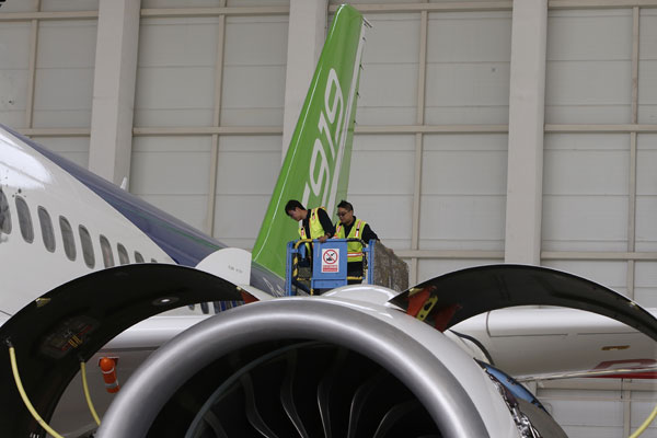 Two technicians inspect an engine on the C919, China's first domestically produced single-aisle passenger jet, after a taxiing test on Wednesday.(Photo by Yin Liqin/China Daily) Two technicians inspect an engine on the C919, China's first domestically produced single-aisle passenger jet, after a taxiing test on Wednesday.(Photo by Yin Liqin/China Daily)