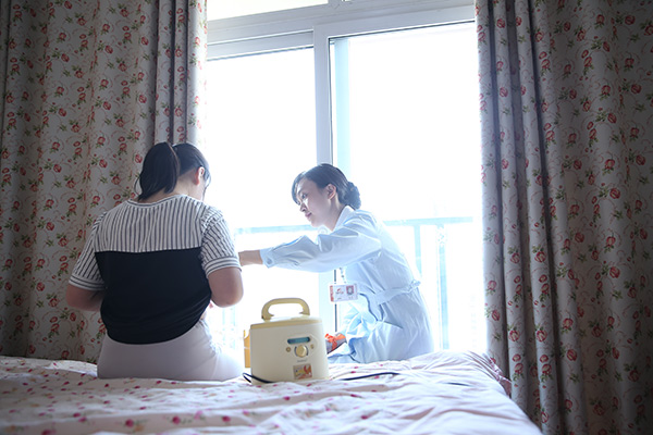 A nurse helps Wei Na to collect brest milk at Wei's home. (Photo provided to China Daily) A nurse helps Wei Na to collect brest milk at Wei's home. (Photo provided to China Daily)