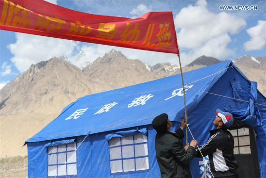 Rescuers set up a banner for a temporary kindergarten of an emergency shelter in Quzgun Village of quake-hit Taxkorgan County, northwest China's Xinjiang Uygur Autonomous Region, May 12, 2017. (Xinhua/Li Jing) Rescuers set up a banner for a temporary kindergarten of an emergency shelter in Quzgun Village of quake-hit Taxkorgan County, northwest China's Xinjiang Uygur Autonomous Region, May 12, 2017. (Xinhua/Li Jing)