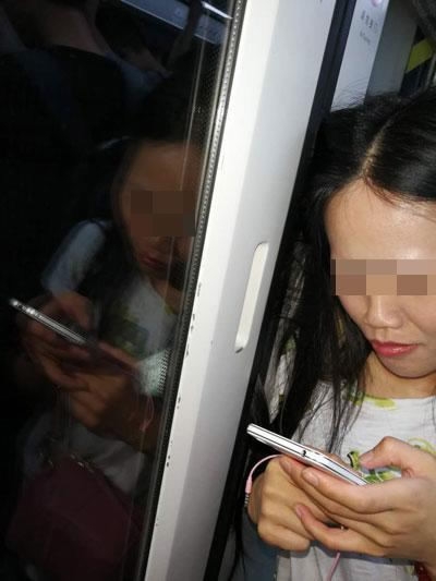 A woman plays with her mobile phone as she waits for doors to open and free her locks. (Photo/ycwb.com) A woman plays with her mobile phone as she waits for doors to open and free her locks. (Photo/ycwb.com)