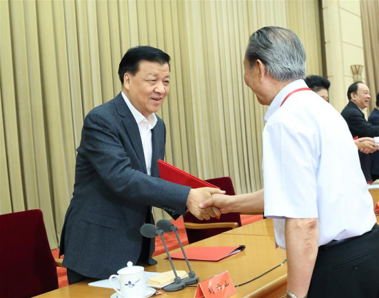 Liu Yunshan, a member of the Standing Committee of the Political Bureau of the Communist Party of China (CPC) Central Committee, awards a certificate to an author whose work is collected in