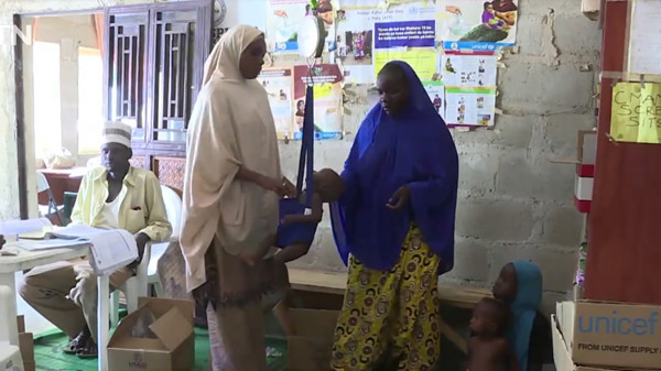 A staff member in a children's clinic in Dalori IDP camp weighs Bala Umar. (CGTN Photo) A staff member in a children's clinic in Dalori IDP camp weighs Bala Umar. (CGTN Photo)
