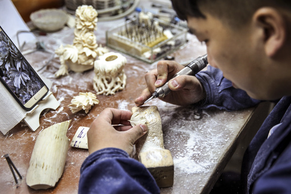 Guo Chen carves a piece of ivory at his desk at the Beijing Ivory Carving Factory. (Photo by Zou Hong/China Daily) Guo Chen carves a piece of ivory at his desk at the Beijing Ivory Carving Factory. (Photo by Zou Hong/China Daily)