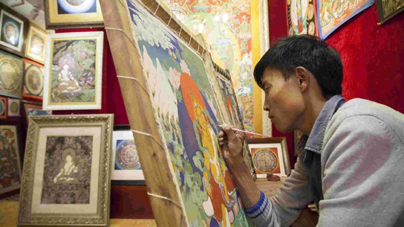 A Thangka painter learns to master the skill. (Photo/CGTN