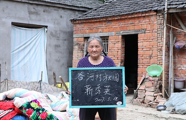 Jin Xiuying verifies renovations to her house to qualify for a subsidy from the local government. ZHU LIXIN/CHINA DAILY Jin Xiuying verifies renovations to her house to qualify for a subsidy from the local government. ZHU LIXIN/CHINA DAILY