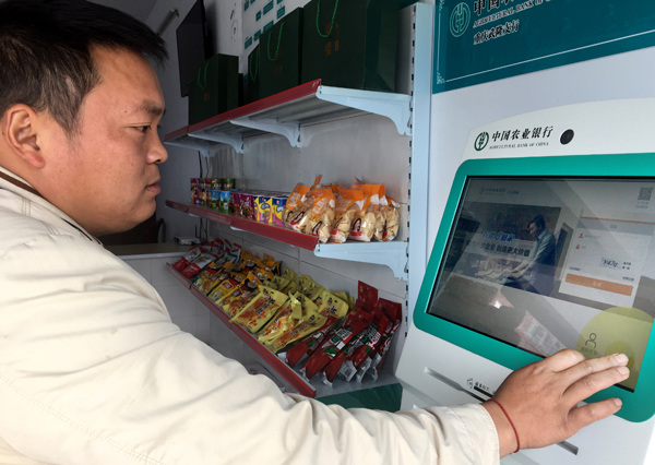 Xiao Chuanguo, a resident of Fazi village in Chongqing's Wulong district, uses Agricultural Bank of China's integrated financial services on a bank terminal.(Photo by Tan Yingzi/China Daily) Xiao Chuanguo, a resident of Fazi village in Chongqing's Wulong district, uses Agricultural Bank of China's integrated financial services on a bank terminal.(Photo by Tan Yingzi/China Daily)