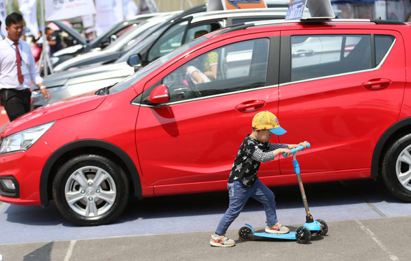 A child riding a scooter passes by a car at an auto exhibition in Beijing. (ZOU HONG / CHINA DAILY) A child riding a scooter passes by a car at an auto exhibition in Beijing. (ZOU HONG / CHINA DAILY)