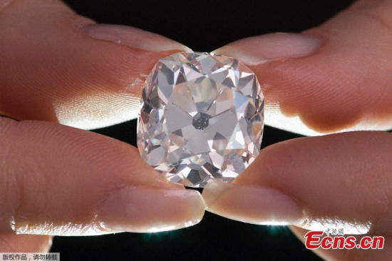 A member of Sotheby's staff poses holding a 26.27 carat, cushion-shaped, white diamond, for sale at Sotheby's auction house in London on May 22, 2017. (Photo/Agencies) A member of Sotheby's staff poses holding a 26.27 carat, cushion-shaped, white diamond, for sale at Sotheby's auction house in London on May 22, 2017. (Photo/Agencies)