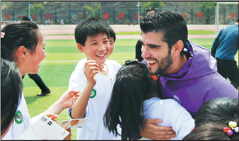 Victor De Arce, of the Real Madrid Foundation, hugs a student after a soccer training session. Victor De Arce, of the Real Madrid Foundation, hugs a student after a soccer training session.