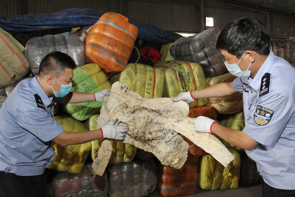 Members of the anti-smuggling unit of the Xiamen Customs, Fujian province, uncover illegally imported waste material. LEI GUOHUA/CHINA DAILY Members of the anti-smuggling unit of the Xiamen Customs, Fujian province, uncover illegally imported waste material. LEI GUOHUA/CHINA DAILY