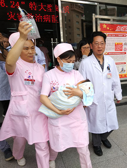 Qiao Daochun, an infant whose crying awoke his parents and helped save them from the landslide, is transferred to a hospital in Chengdu, Sichuan province.Yang Li / For China Daily Qiao Daochun, an infant whose crying awoke his parents and helped save them from the landslide, is transferred to a hospital in Chengdu, Sichuan province.Yang Li / For China Daily