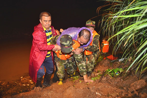 Rescuers help villagers to safety on Tuesday night in Zhiping village in Shaoyang city, Hunan province, where roads to the village were cut off by landslides triggered by heavy rainfall.Tang Jun / For China Daily Rescuers help villagers to safety on Tuesday night in Zhiping village in Shaoyang city, Hunan province, where roads to the village were cut off by landslides triggered by heavy rainfall.Tang Jun / For China Daily