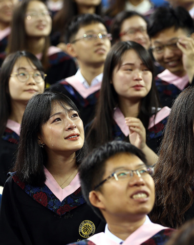 Graduates of Peking University weep while watching videos reviewing their college days during a graduation ceremony in Beijing on Tuesday. (Photo by Zou Hong/China Daily) Graduates of Peking University weep while watching videos reviewing their college days during a graduation ceremony in Beijing on Tuesday. (Photo by Zou Hong/China Daily)