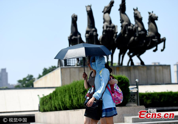 Tourists protect themselves from sunlight in Luoyang City, Henan Province, July 10, 2017. The city has issued an orange alert, with heatwave temperatures at 37 degrees centigrade. (Photo/VCG) Tourists protect themselves from sunlight in Luoyang City, Henan Province, July 10, 2017. The city has issued an orange alert, with heatwave temperatures at 37 degrees centigrade. (Photo/VCG)