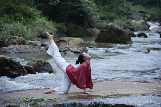 A woman practices yoga on the bank of a creek in Shuiwei Township in Xuyong County, southwest China's Sichuan Province, July 4, 2017. (Xinhua/Li Xin) A woman practices yoga on the bank of a creek in Shuiwei Township in Xuyong County, southwest China's Sichuan Province, July 4, 2017. (Xinhua/Li Xin)