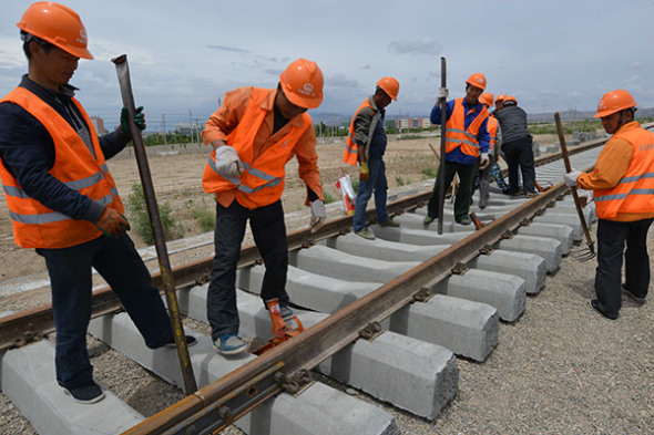 Workers lay track for the Korla-Golmud Railway in the Xinjiang Uygur autonomous region on Saturday. (Que Hure / For China Daily) Workers lay track for the Korla-Golmud Railway in the Xinjiang Uygur autonomous region on Saturday. (Que Hure / For China Daily)